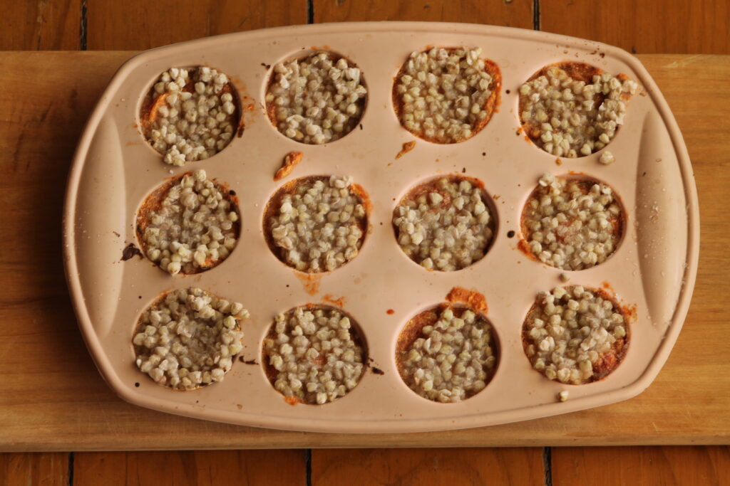Silicon mini muffin tray with 12 frozen portions of baby food buckwheat puttanesca
