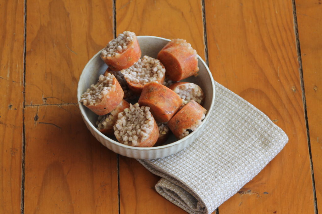 Frozen circular portions of baby food buckwheat puttanesca in a bowl sitting on a tea towel