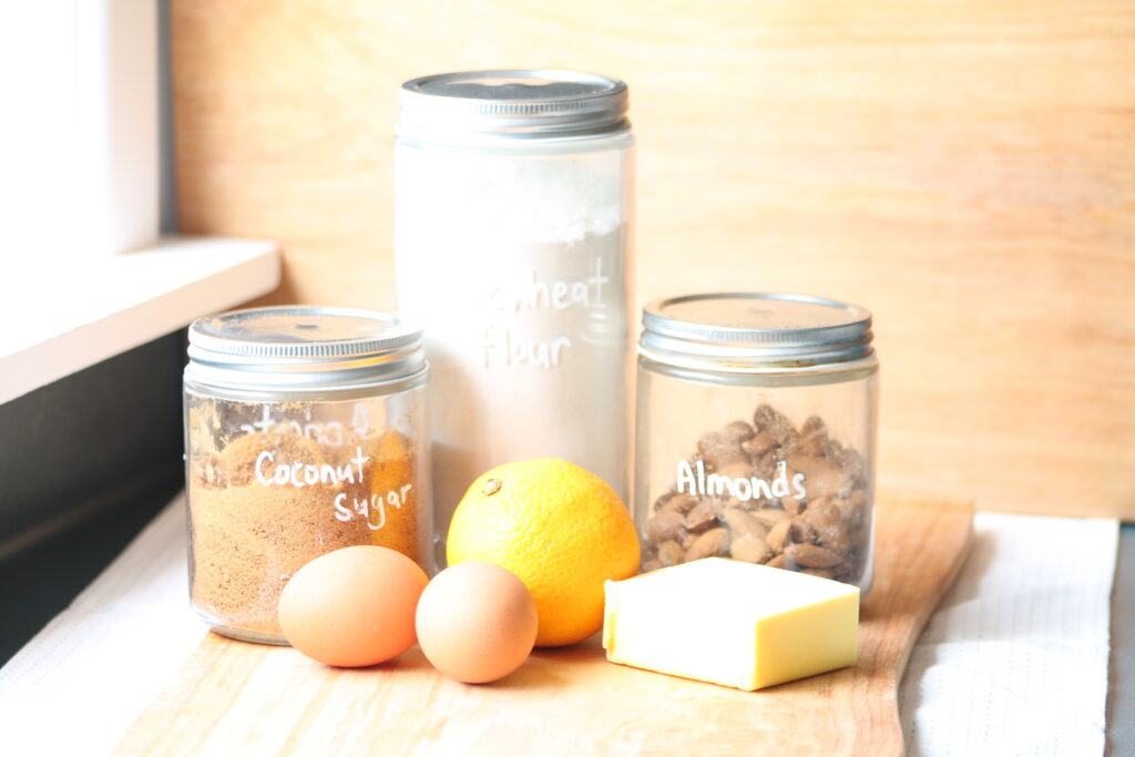 ingredients for whole orange cake on wooden cutting board
